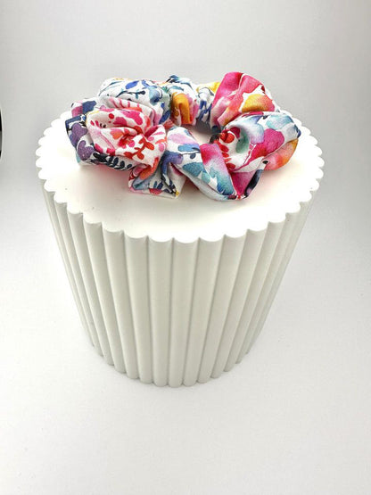 A side view showing the watercolour-like florals of the scrunchie