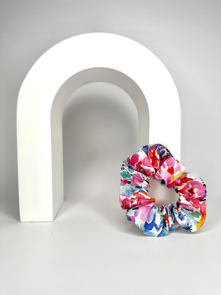 A top view showing the watercolour-like florals of the scrunchie